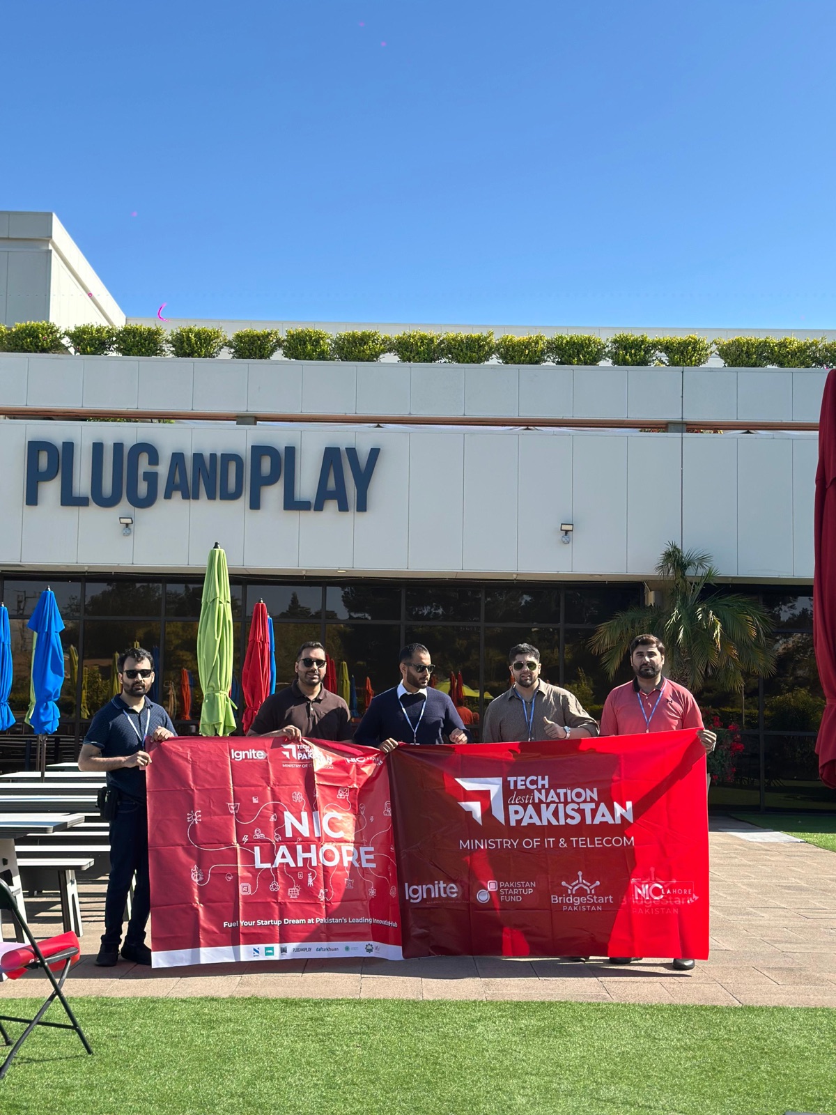 NICL founders with the NIC Lahore banner at Plug and Play
